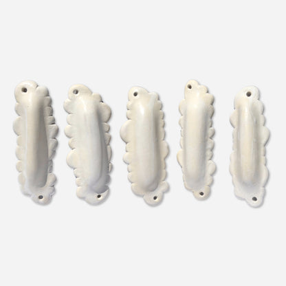 multiple cloud-shaped mezuzah cases in white ceramic displayed in a loose arrangement