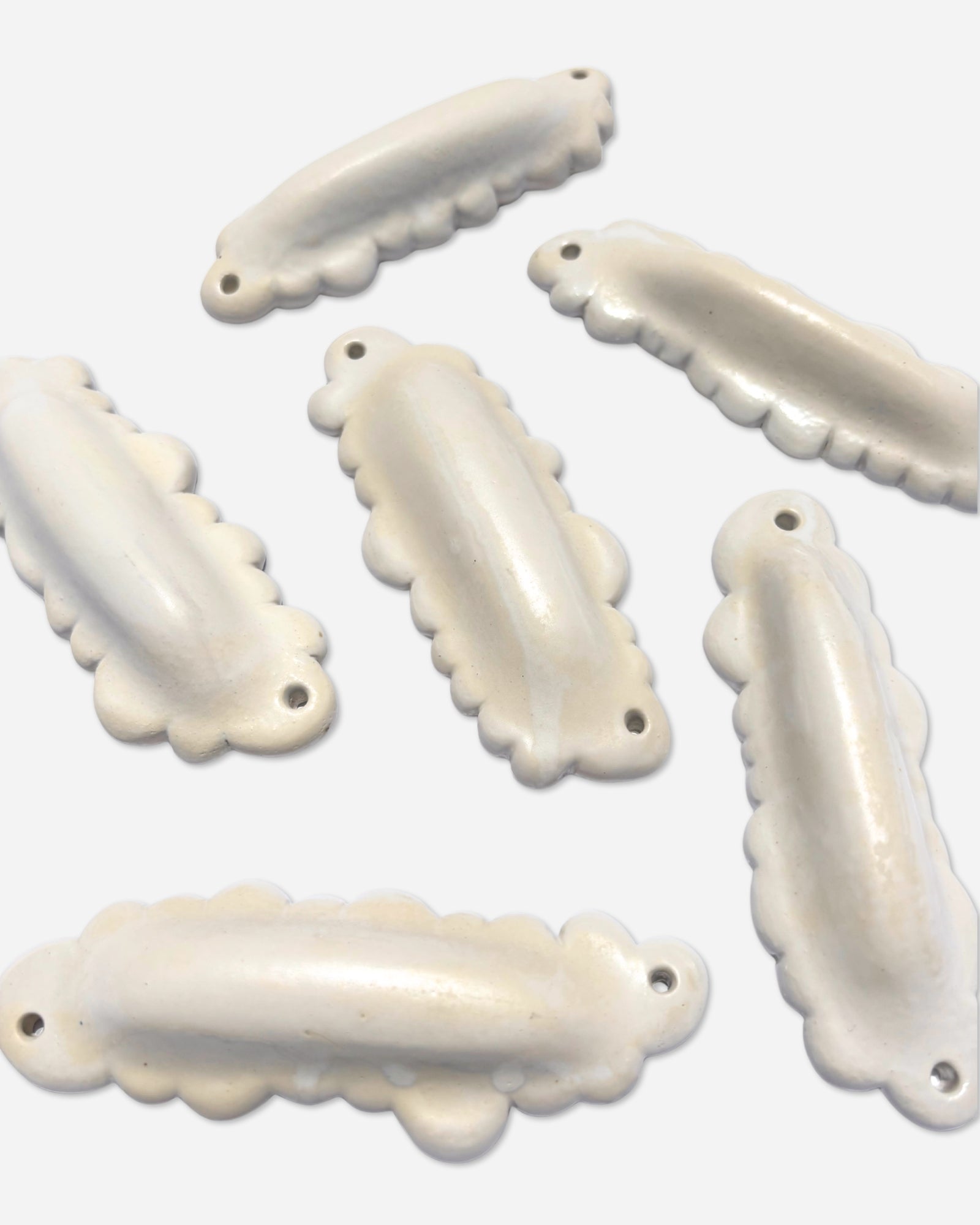 group of handmade ceramic cloud mezuzah cases arranged together showing variation in glaze and form