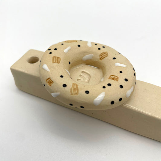 Handmade bagel mezuzah, a unique Jewish home decor piece, perfect for housewarmings, Bar Mitzvahs, or collectors of artisanal Judaica.