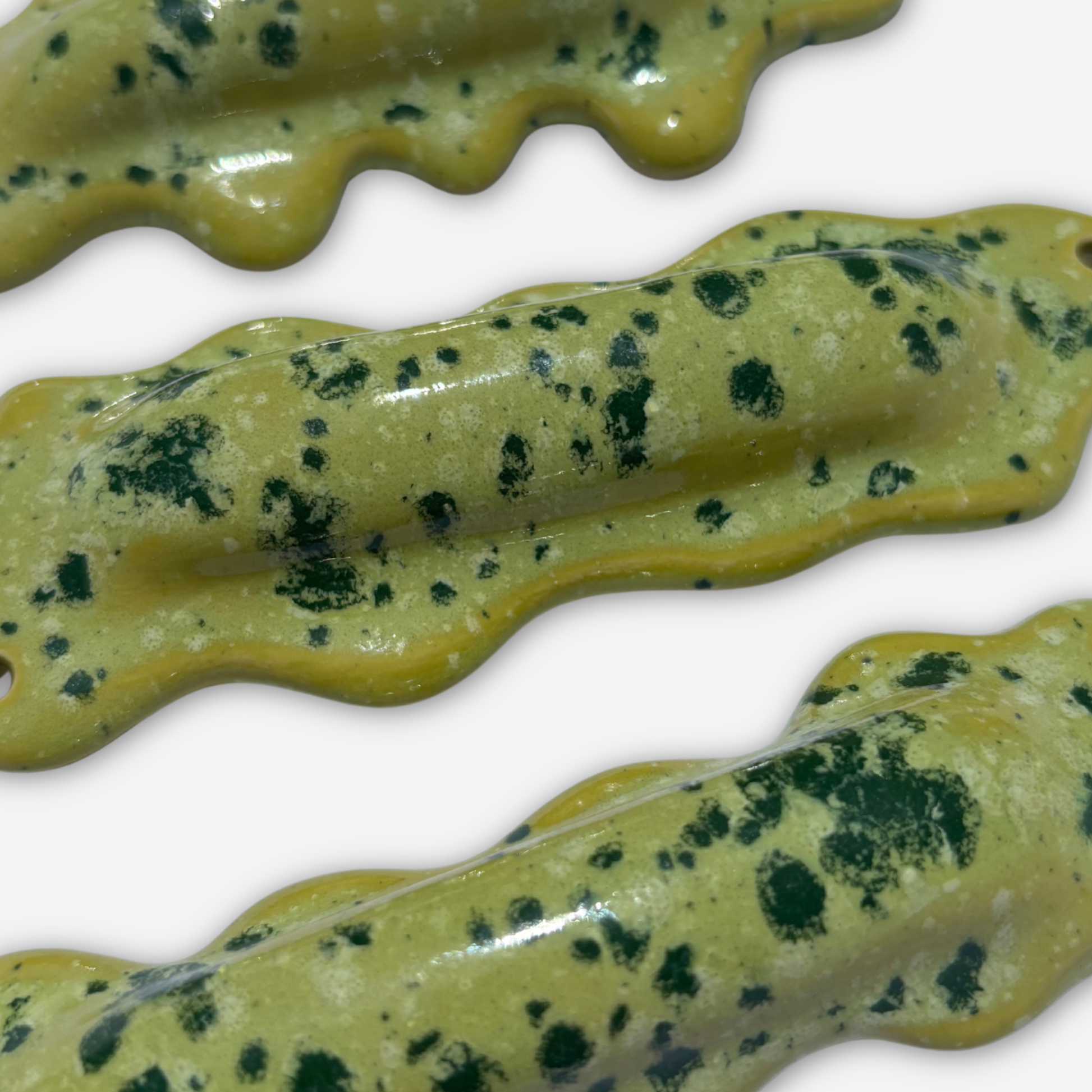 detail of lime green sprinkle glaze ceramic mezuzah case texture with dark green speckles