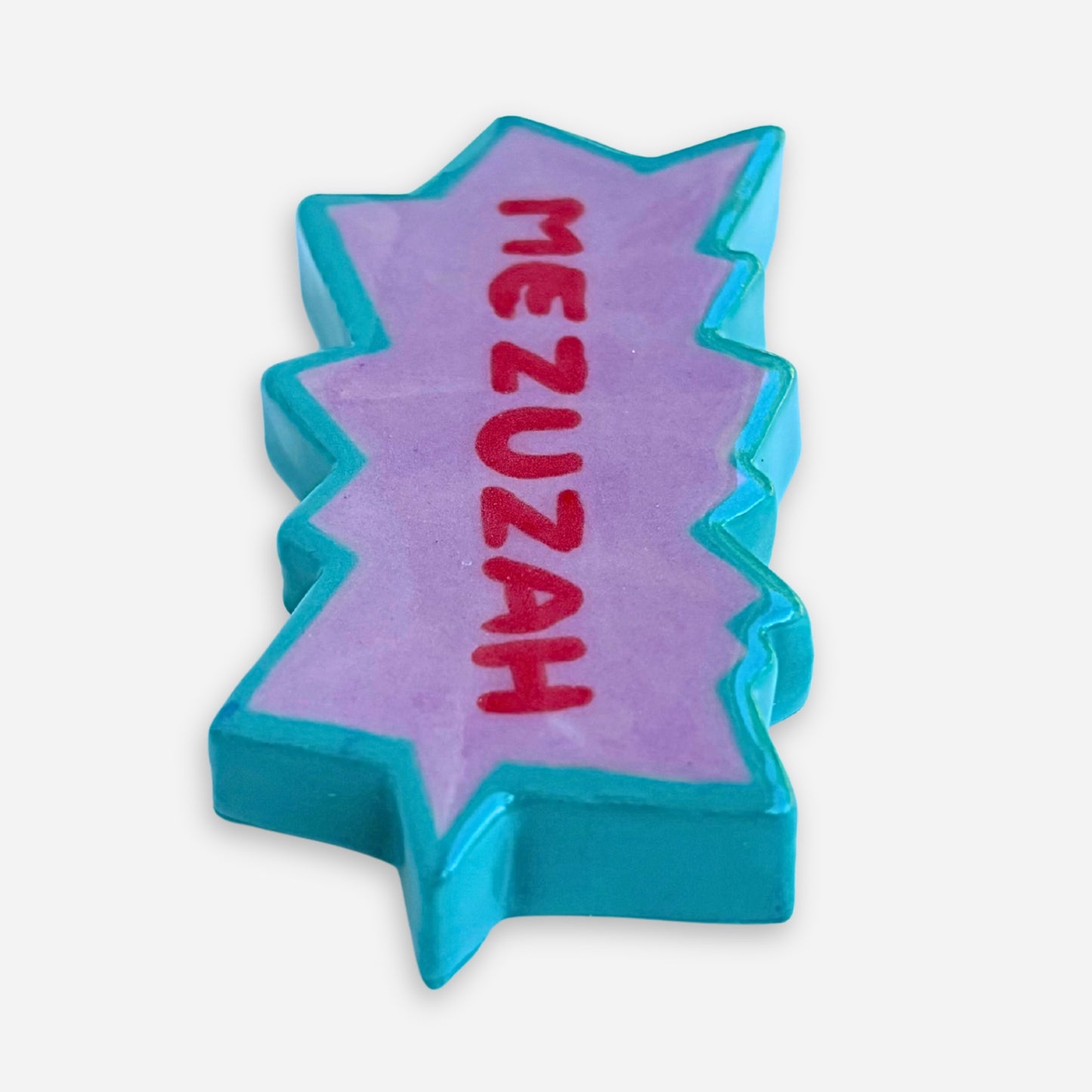 Close up view of the red lettering on the small purple and teal handmade mezuzah case.